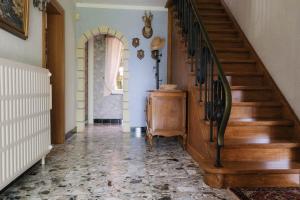 a hallway with a wooden staircase in a house at Les Randonneurs - Maison spacieuse avec jardin in Malmedy