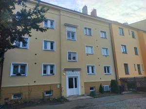 a large yellow building with white windows at Apartmán Matěj in Poděbrady