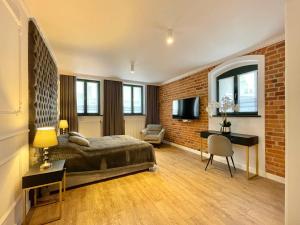 a bedroom with a bed and a brick wall at Miodowa Faktoria # 4 in Toruń