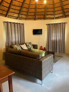 a couch sitting in a living room with curtains at Jock of the Bushveld in Barberton