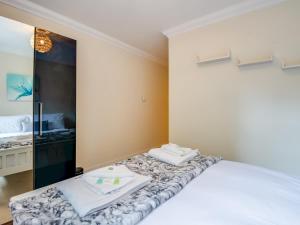 een slaapkamer met een wit bed en een spiegel bij Pass The Keys Quiet 2-Bed Apartment on the Ground Floor in Canterbury