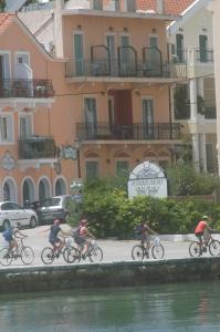 a group of people riding bikes down a street at Marina rooms in Argostoli