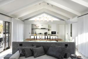 a living room with a couch and a kitchen at PREMIUM CAPE Camps Bay Lodge in Cape Town