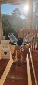 a bottle of wine in a bucket on a table at APPARTEMENT LES PINS PENCHES Hardelot plage in Neufchâtel-Hardelot