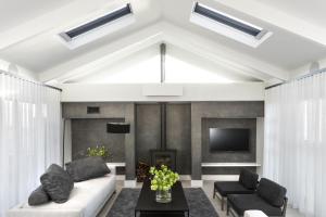 a living room with a couch and a tv at PREMIUM CAPE Camps Bay Lodge in Cape Town