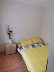 ein kleines Schlafzimmer mit einem Bett und einem Nachttisch in der Unterkunft Kole Apartman in Pale