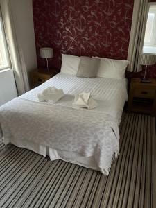 a bedroom with a large white bed with a red wall at The Castle Tavern in Richmond