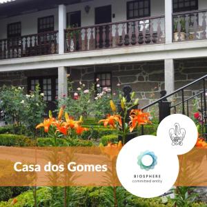 una foto de un edificio con flores delante de él en Casa Dos Gomes en Viseu