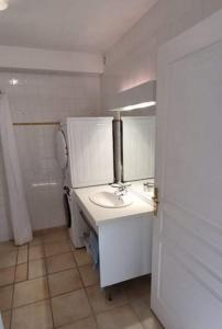 La salle de bains blanche est pourvue d'un lavabo et de toilettes. dans l'établissement APPARTEMENT LES PINS PENCHES Hardelot plage, à Neufchâtel-Hardelot