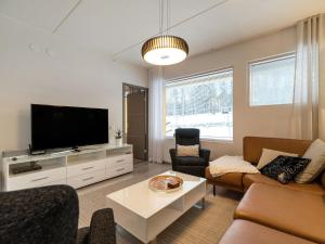 a living room with a couch and a tv at Holiday Home Tunturinlaita c2 by Interhome in Sirkka