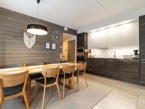 a kitchen and dining room with a wooden table and chairs at Holiday Home Tunturinlaita c2 by Interhome in Sirkka