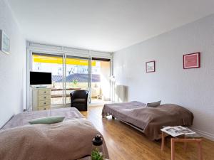 een slaapkamer met 2 bedden en een televisie. bij Studio L'Alma-7 by Interhome in Saint-Jean-de-Luz