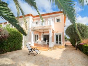 a villa with a balcony and a chair in a courtyard at Holiday Home Residencial Bel-Air by Interhome in Calpe