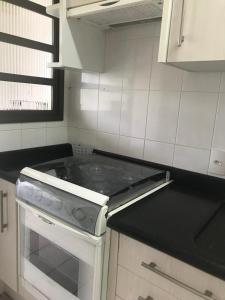 a kitchen with a stove top oven in a kitchen at BEIRA DA PRAIA com VISTA TOTAL DO MAR in Florianópolis