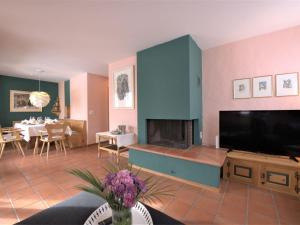 a living room with a fireplace and a tv at Apartment Chesa Maurus A5 by Interhome in St. Moritz