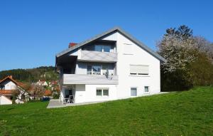 a white house on top of a green hill at Ferienwohnung HappyNES in Bad Neustadt an der Saale