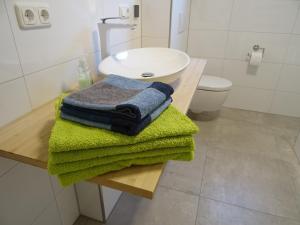 un bagno con asciugamani verdi su un tavolo con un lavandino di Ferienwohnung HappyNES a Bad Neustadt an der Saale Altre 46 foto