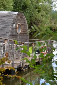 a circular window on the side of a house in the water at Lodges des grands crus in Chablis