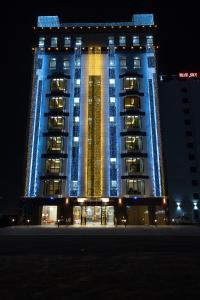 un grand bâtiment avec des lumières bleues et jaunes sur lui dans l'établissement Grand Mirage Hotel, à Ma‘ābīlah