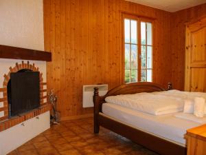 a bedroom with a bed and a fireplace at Chalet Chalet 4 pièces 969 by Interhome in Moleson