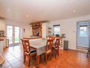 a kitchen with a table and chairs in a room at Job's Cottage in Snettisham