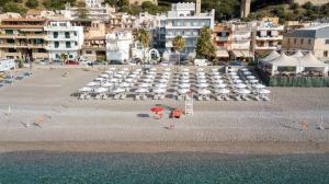a beach with chairs and umbrellas on the beach at Albatros Beach Hotel in Letojanni