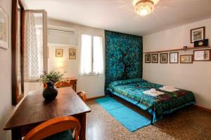 a room with a bed and a table with a vase on it at Santi Apostoli Home in Venice