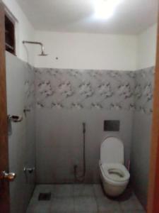 a small bathroom with a toilet and a shower at Sugaya in Matara