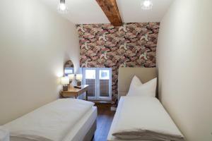 two beds in a room with a stone wall at Altstadthotel Zur Börse in Goslar