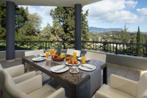 a table and chairs on the balcony of a house at Villa Iremia by Rodostamo Collection in Gazátika