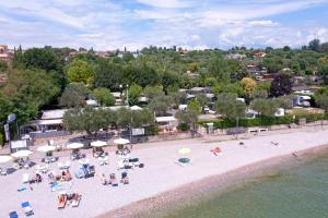 una vista aérea de una playa con sillas y sombrillas en Camping Porto srl, en Moniga del Garda