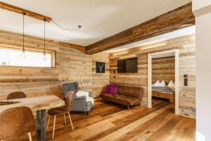 Zimmer mit Holzwänden, einem Tisch und Stühlen in der Unterkunft Biochalet-Ebenbauer in Schladming
