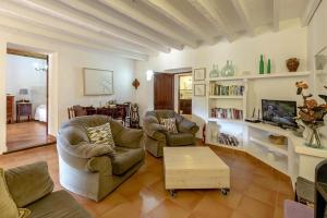 sala de estar con 2 sillas y TV en Villa Panada, en Pollensa