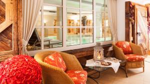 a room with two chairs and a table and a window at Superior Hotel Tirolerhof - Zell am See in Zell am See
