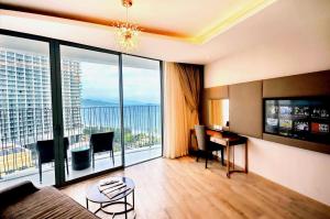 a living room with a desk and a large window at RIS Panorama Condotel in Nha Trang