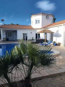 a villa with a swimming pool and a house at Villa voor 8 personen met zwembad in Calafat