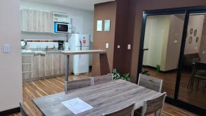 eine Küche und ein Esszimmer mit einem Holztisch in einem Zimmer in der Unterkunft Amplio y Cómodo Depto. 6 Personas in Salta