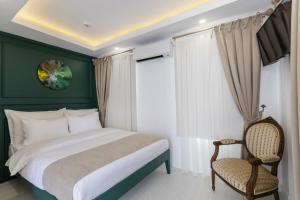 a bedroom with a large bed and a chair at KIANA KALEİÇİ in Antalya