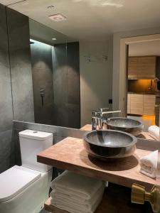 a bathroom with two sinks on a counter with a toilet at Baqueira321 Ubicación Privilegiada. in Baqueira-Beret