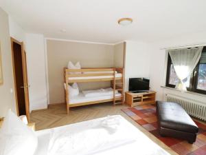 a room with a bedroom with a bed and a tv at Haus Wintersonne in Feldberg