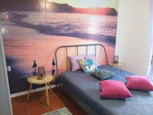 a bedroom with a bed with a painting of the beach at Silva's House in Vila Nova de Milfontes