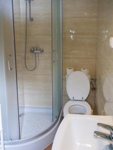 a bathroom with a shower and a toilet and a sink at Malinowy Dworek - Spokojny wypoczynek nad morzem in Ciekocino