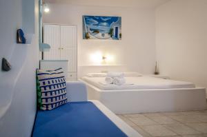 a small room with two beds and a couch at Paleochori Studios in Paliochori