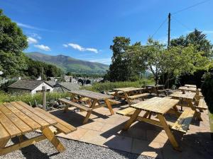 a row of wooden picnic tables on a patio at The Coledale Inn in Keswick