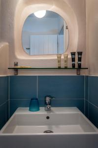 a bathroom with a white sink and a mirror at Paleochori Studios in Paliochori
