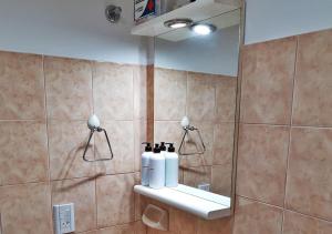 La salle de bains est pourvue d'un lavabo avec 3 bouteilles. dans l'établissement El Garage de los pioneros, à El Calafate
