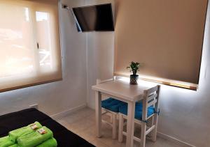 Cette petite chambre dispose d'une table et d'une télévision murale. dans l'établissement El Garage de los pioneros, à El Calafate