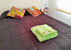 a bed with two towels and pillows on it at El Garage de los pioneros in El Calafate