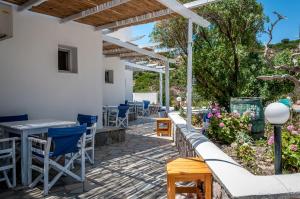 a patio with tables and chairs under a pergola at Paleochori Studios in Paliochori