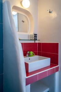 a bathroom with a white sink and a mirror at Paleochori Studios in Paliochori